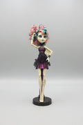 Monster High doll with colorful hair and outfit on a black background