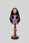 Monster High doll with dark hair and purple dress on a black background