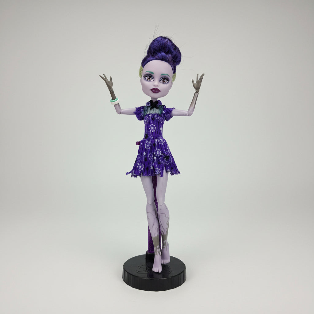 Monster High doll with purple hair and dress on a black background