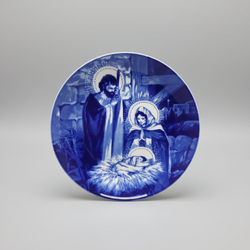 Decorative plate with blue and white religious scene on a dark background