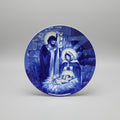 Decorative plate with blue and white religious scene on a dark background