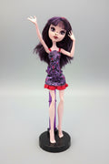 Doll with purple hair and a purple dress on a black background