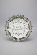 Decorative plate with 'Happy Anniversary' text and decorative border on a black background