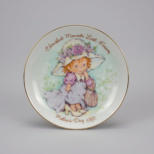 Decorative plate with a girl in a hat and dress, featuring 'Cherished Moments Last Forever' text.