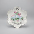 Decorative plate with wedding bells and '25th Anniversary' text on a black background