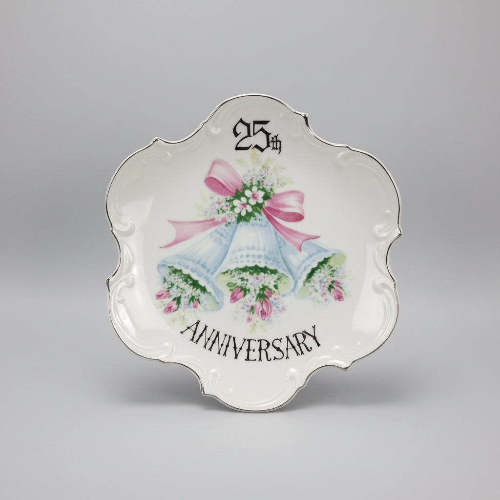 Decorative plate with wedding bells and '25th Anniversary' text on a black background