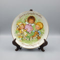 Decorative plate with children illustration and text on a dark background