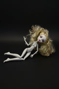 White doll with blonde hair on a black background