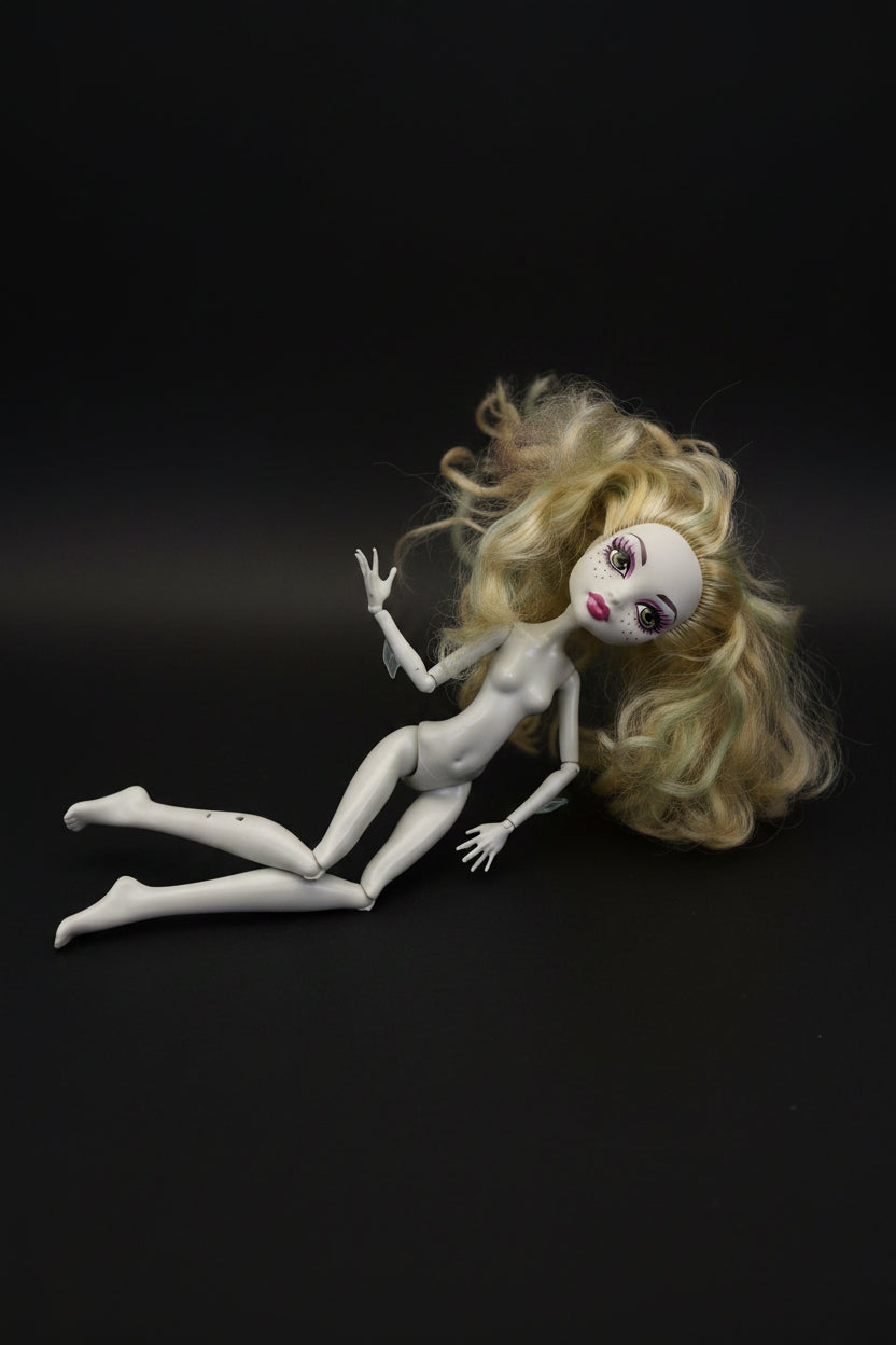 White doll with blonde hair on a black background