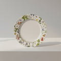 Decorative plate with floral and butterfly design on a black background