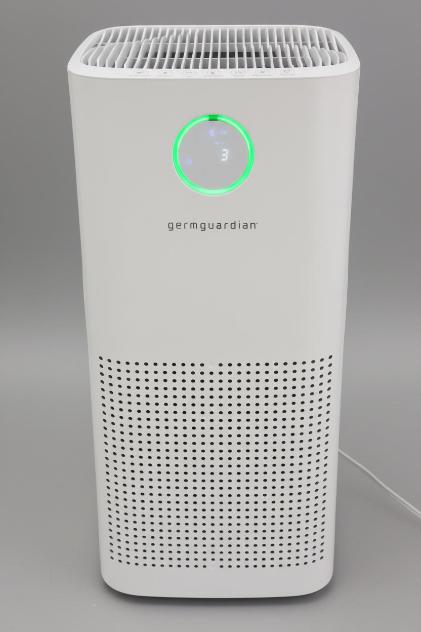 White air purifier with green light indicator on a black background