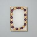 Beaded bracelet in a box with other jewelry items on a dark surface