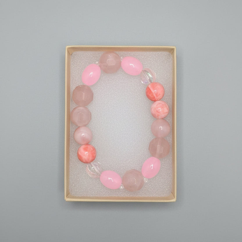 Beaded bracelet with pink and clear beads in a box on a dark surface