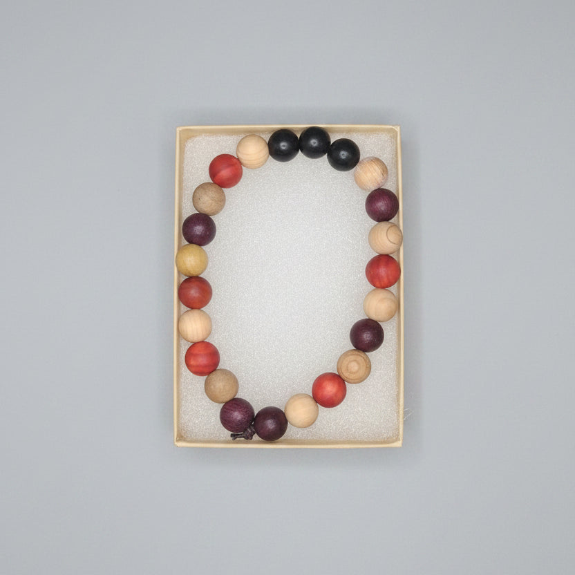 Colorful beaded necklaces displayed on a dark surface with packaging.
