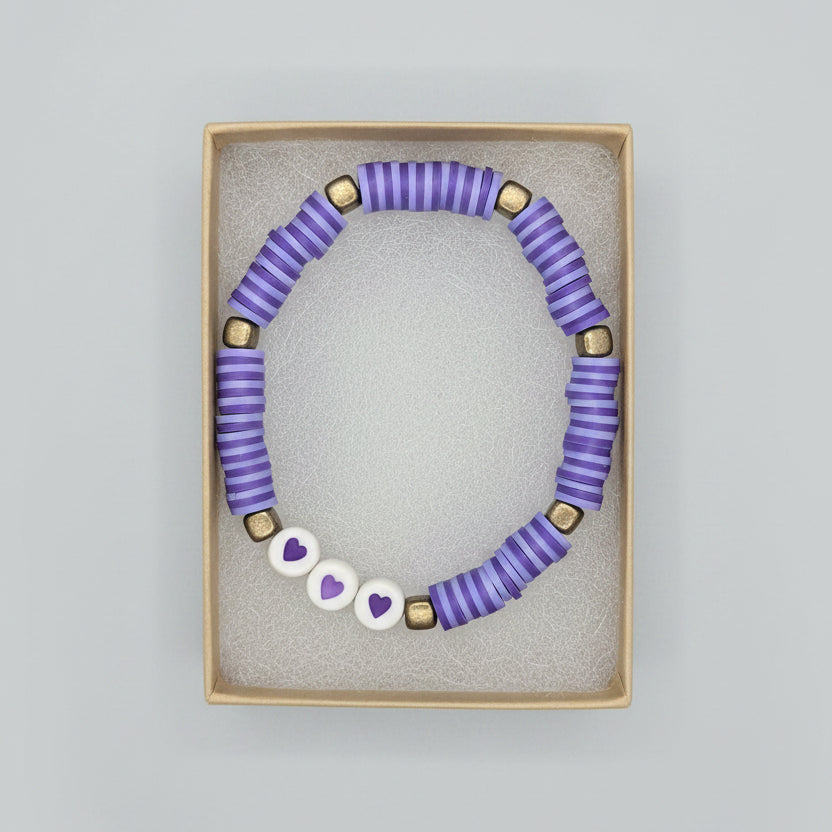 Beaded bracelet with purple and white pattern on a gray background